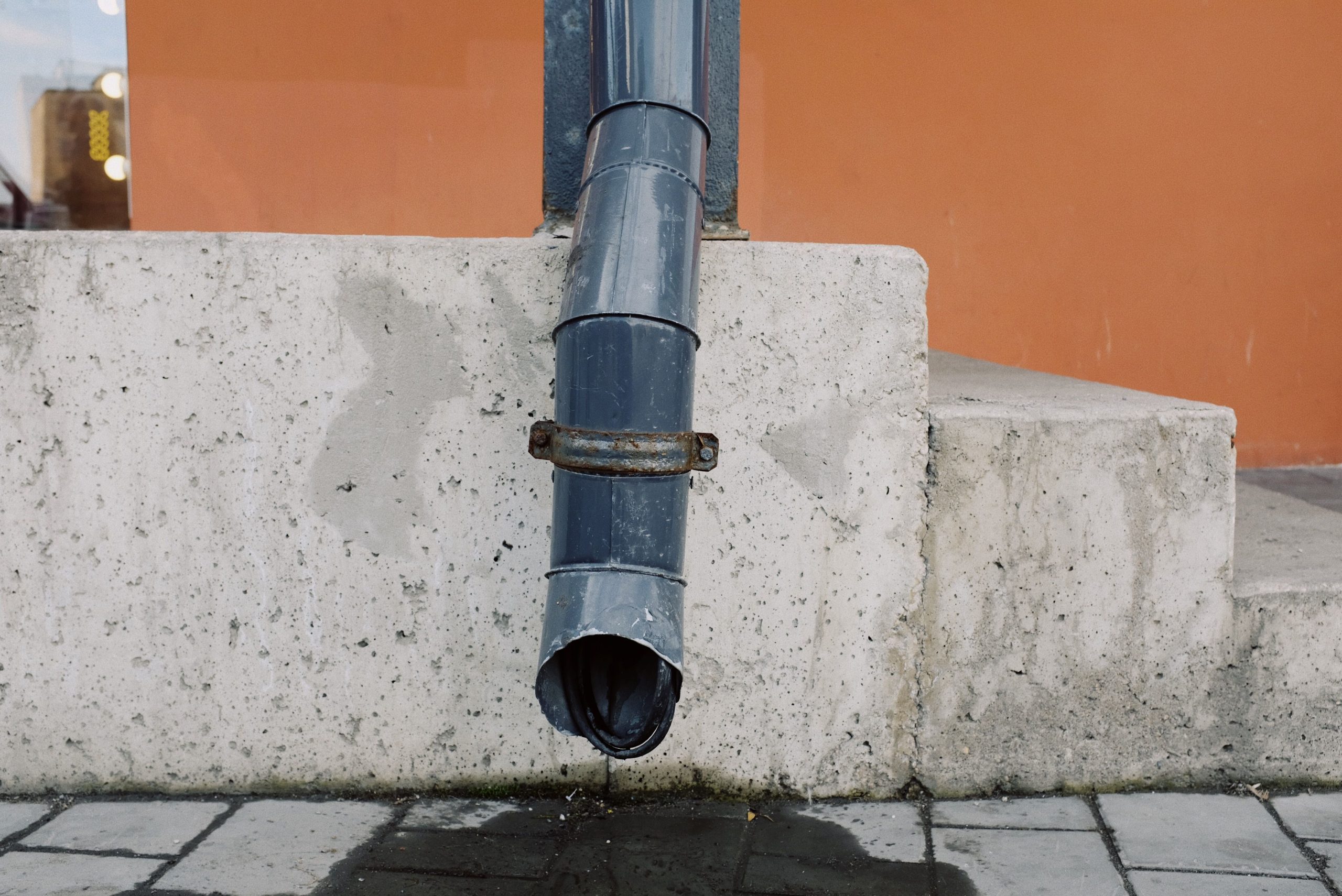 Tuyau métallique usé sur mur béton