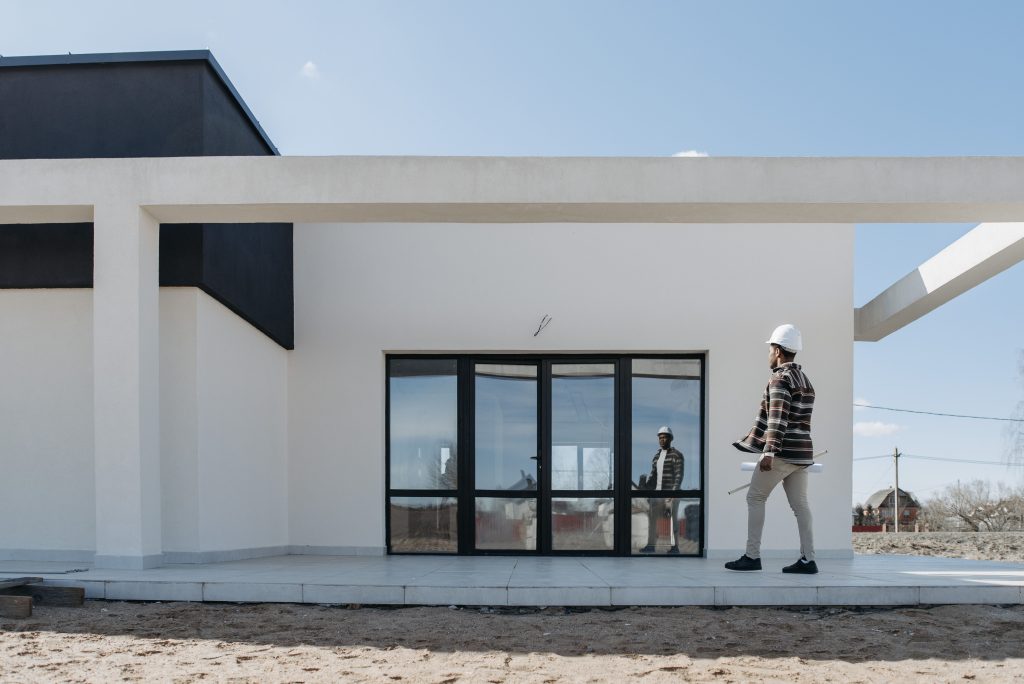 Architecte au casque inspectant maison moderne