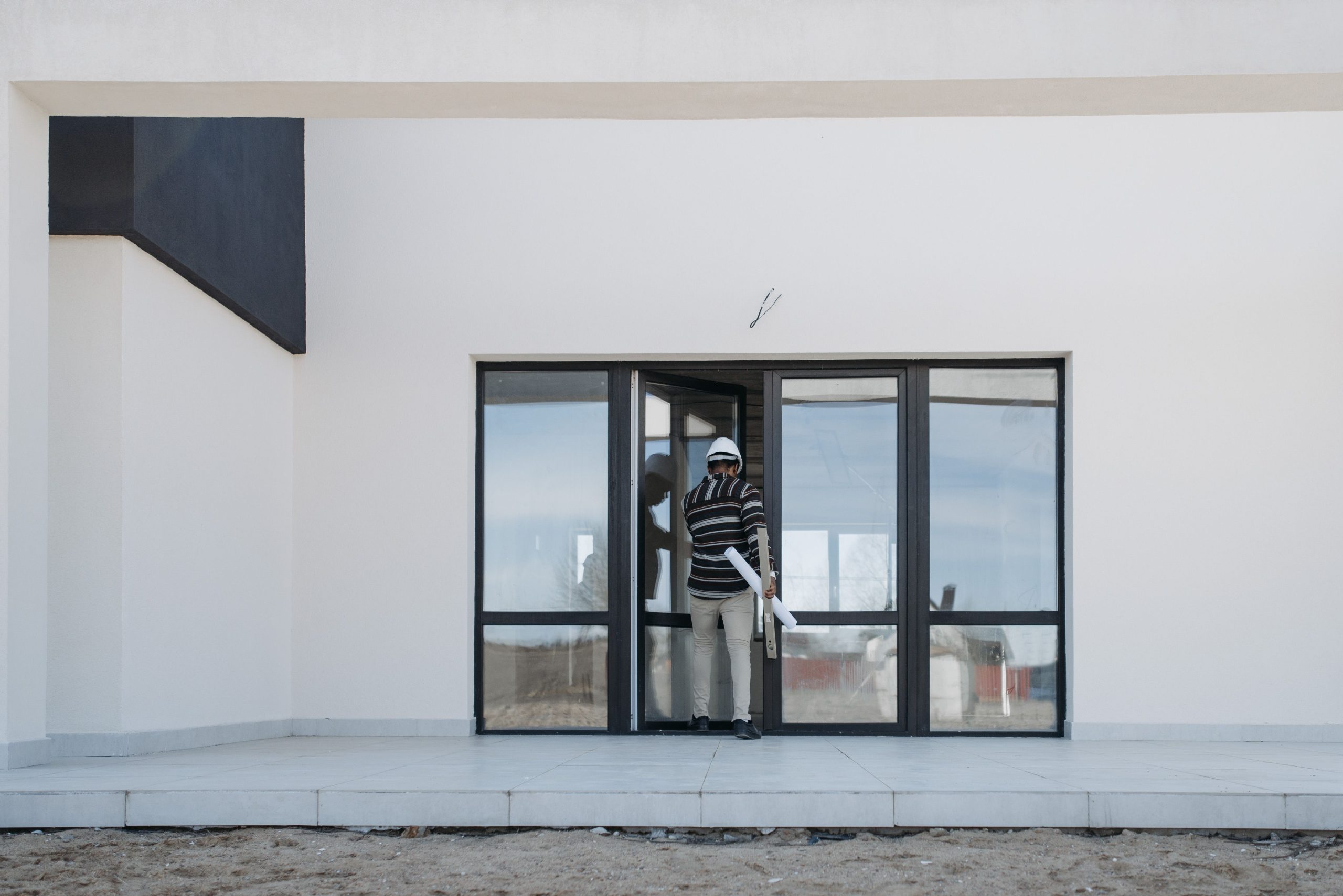 Architecte avec plans sortant bâtiment verre