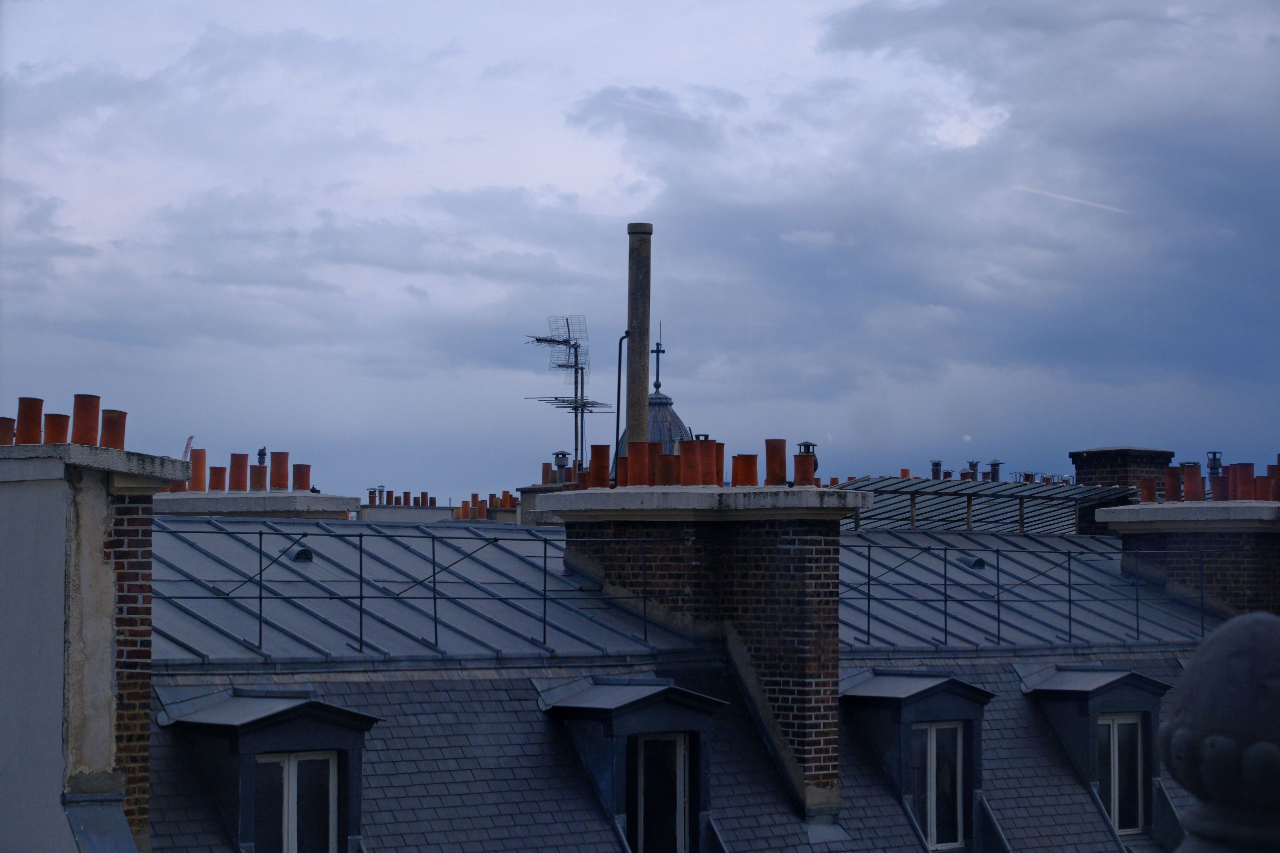 Toits Paris cheminées ciel nuageux crépuscule
