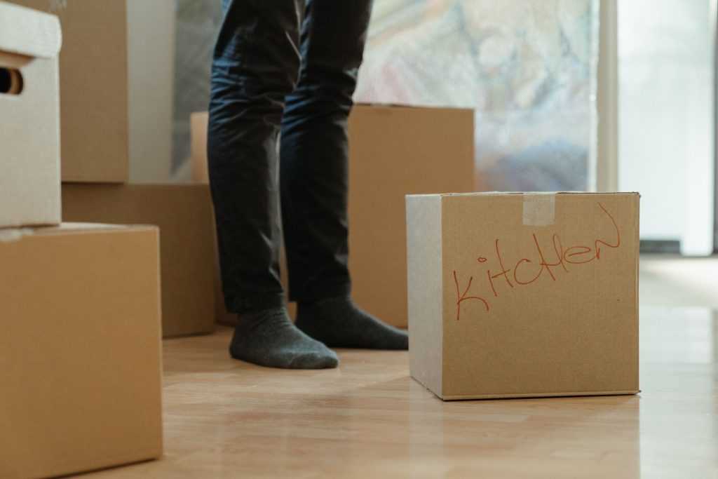 Personne entourée de cartons de déménagement étiquetés