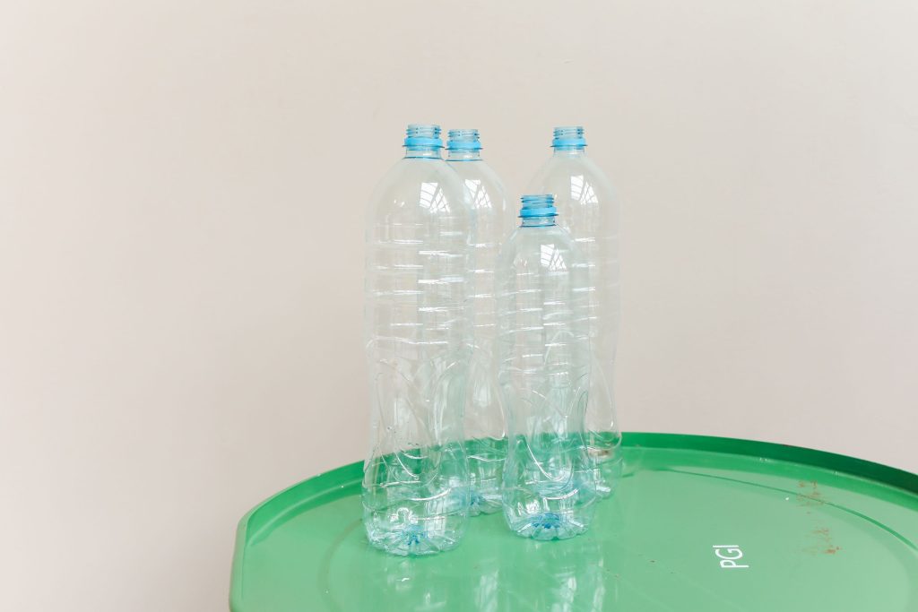 Bidons plastiques transparents sur tambour vert recyclage
