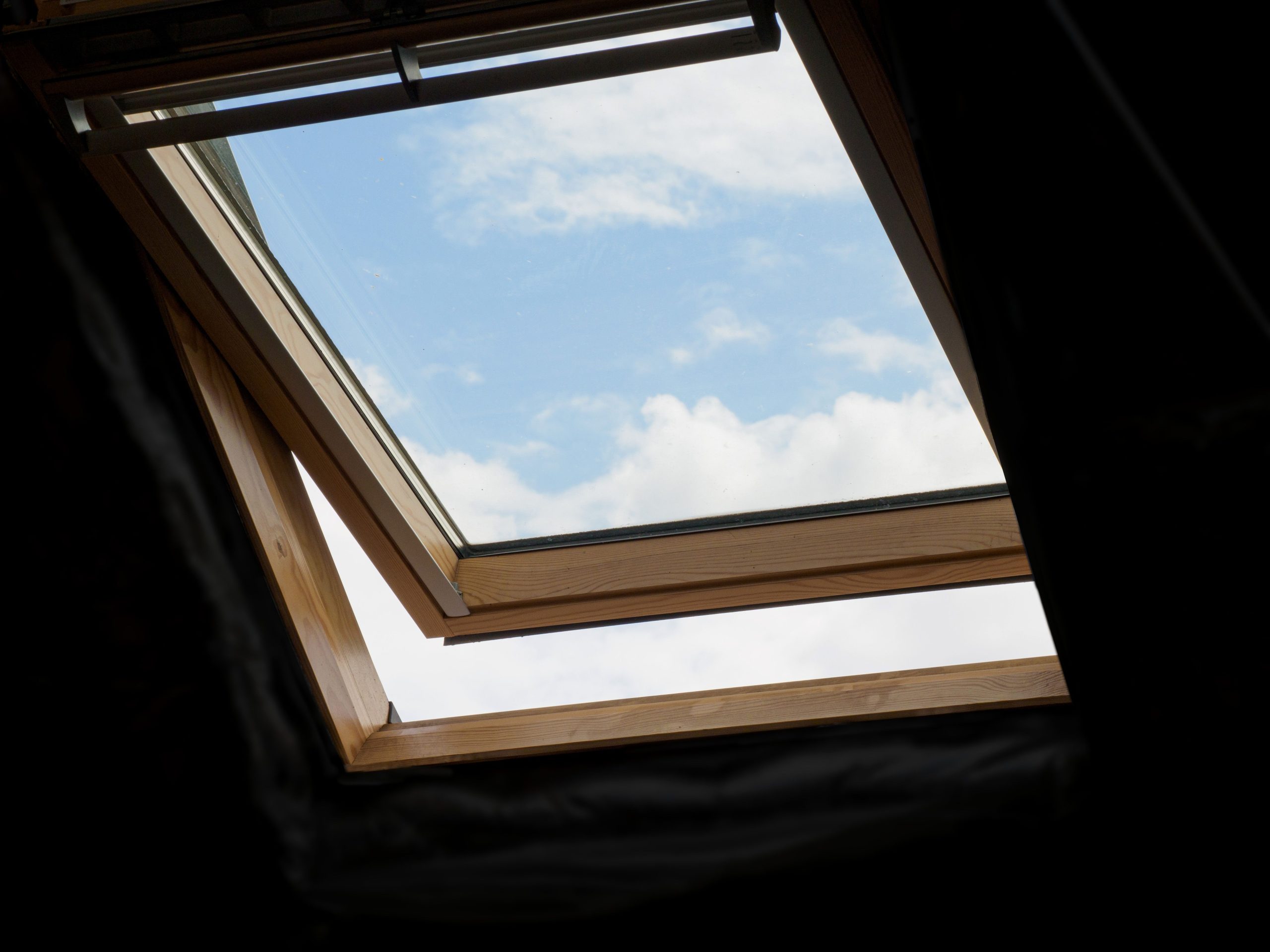 Lucarne ouverte avec ciel bleu et nuages blancs