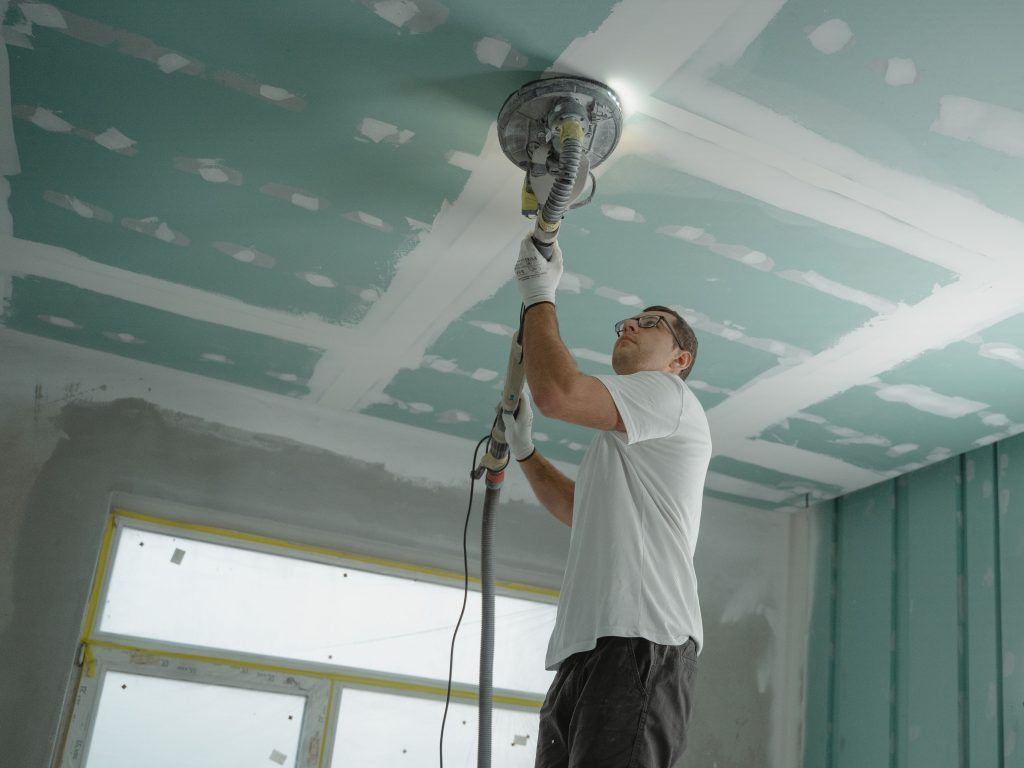 Ouvrier ponce le plafond lors rénovation
