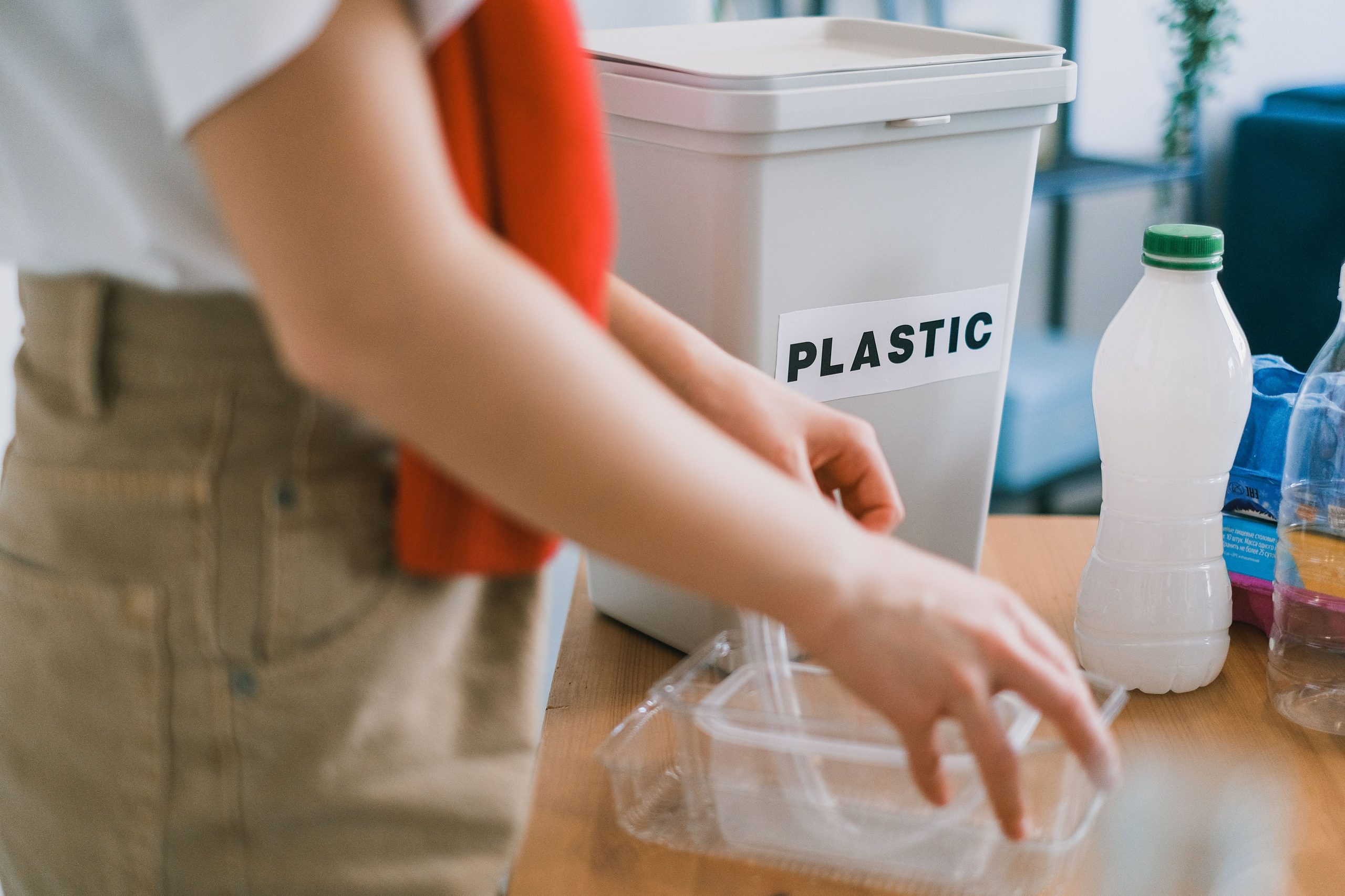 Femme triant ses déchets plastiques dans seau