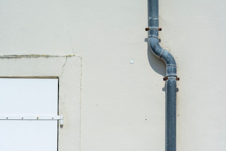 Tuyau d'évacuation gris sur mur extérieur