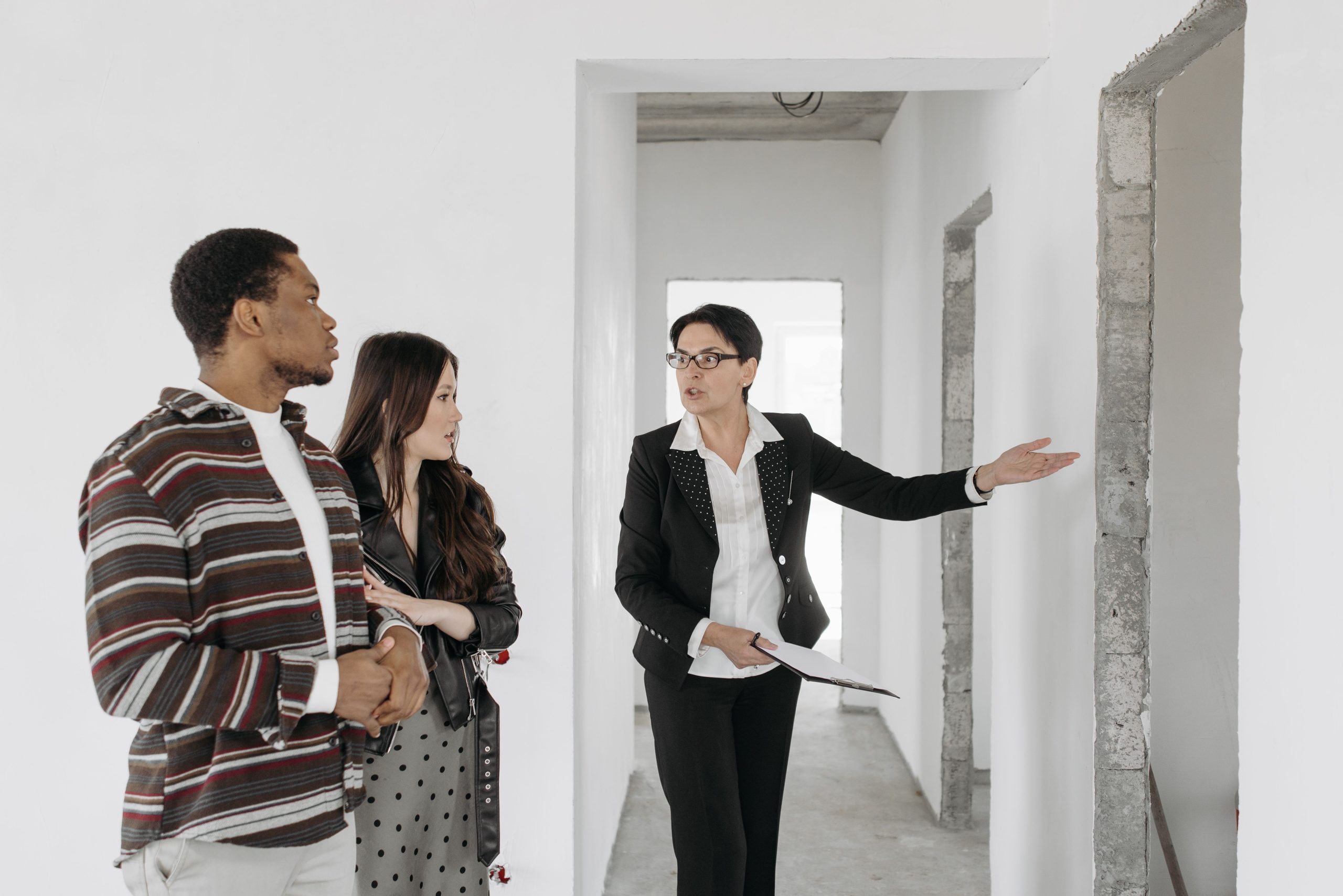 Agent immobilier presente maison couple discute