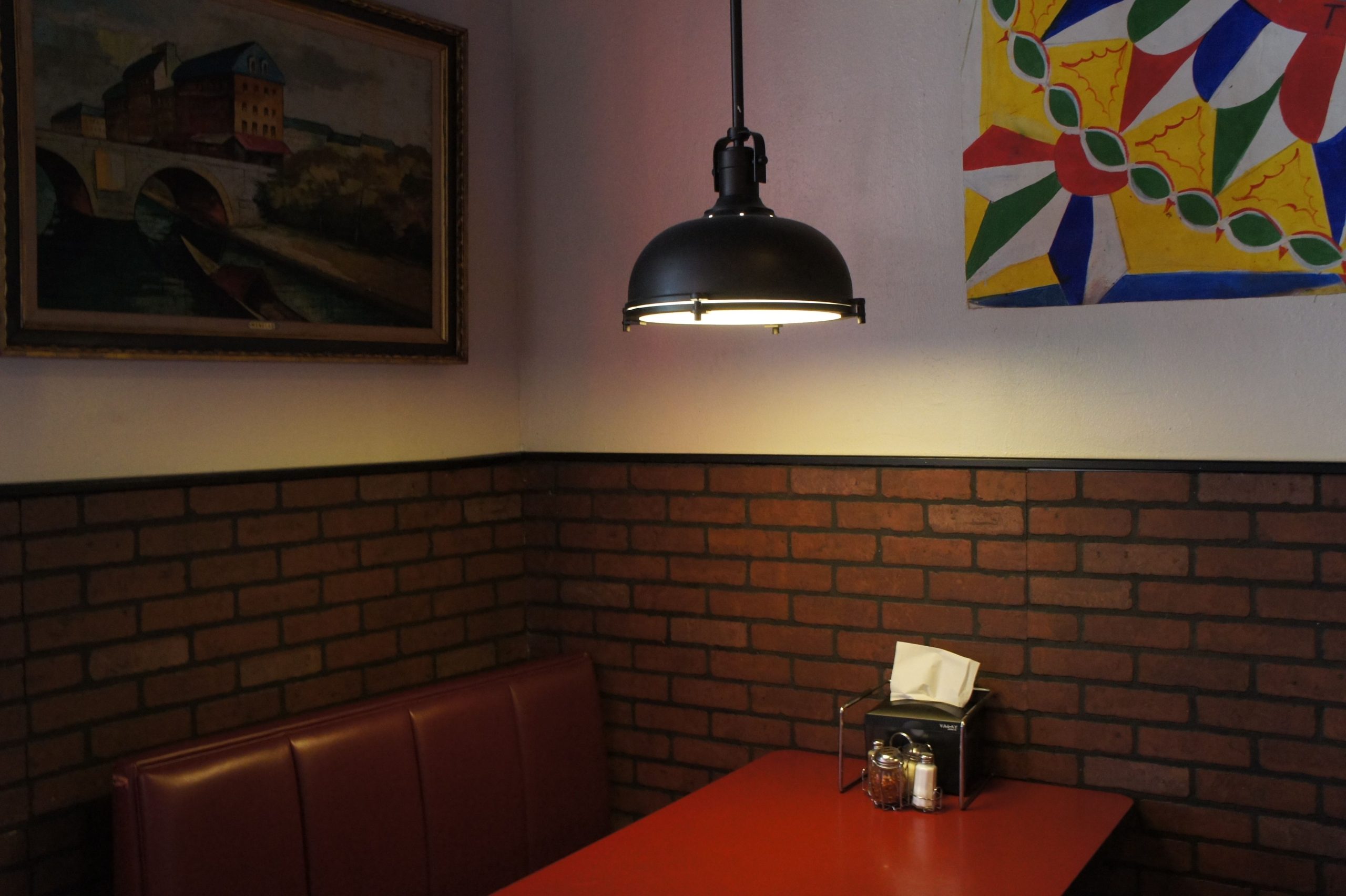 Banquette restaurant rouge murs briques design moderne