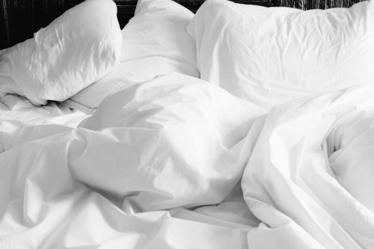 Lit blanc confortable avec draps doux et oreillers moelleux.