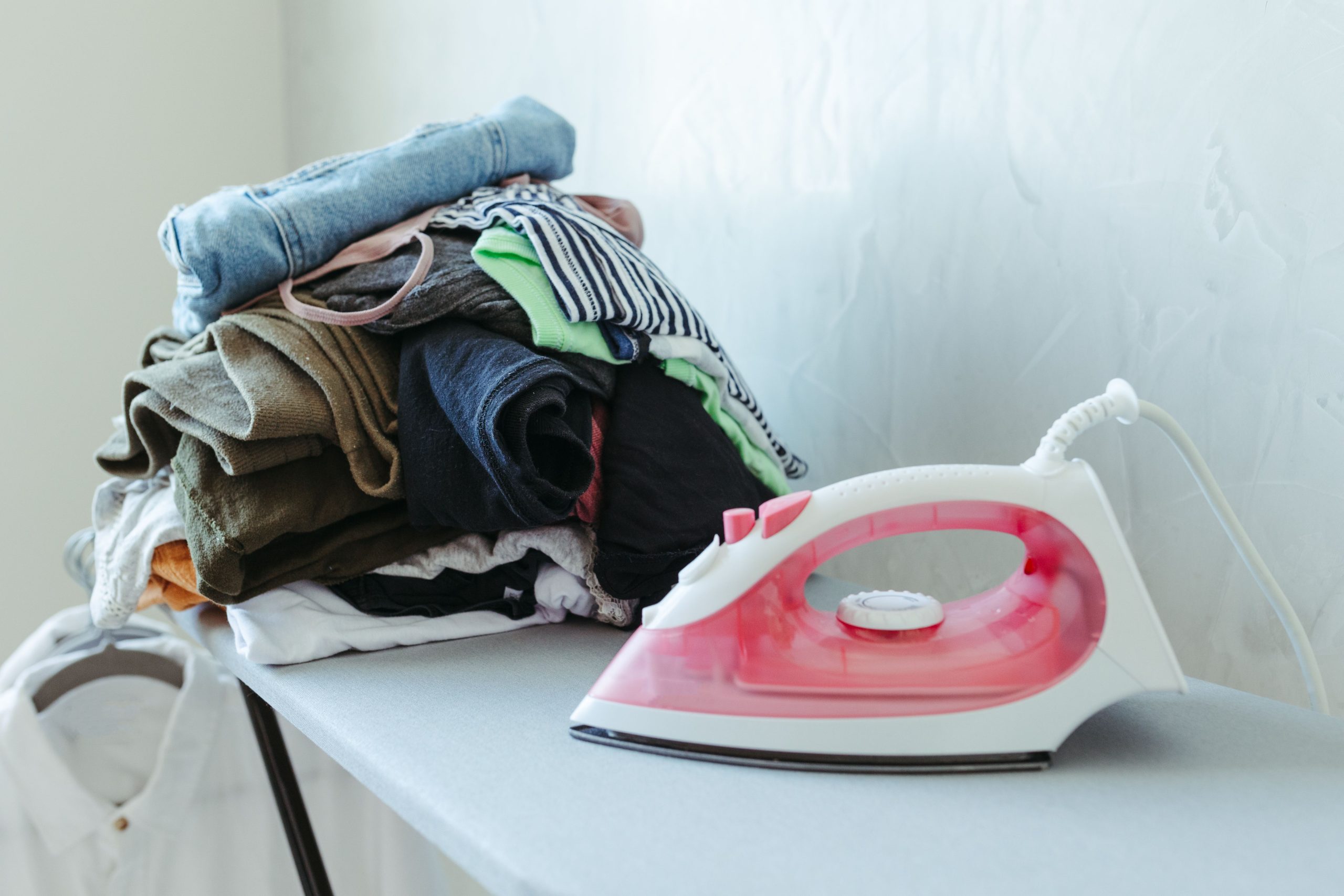 Pile de vêtements prêts à être repassés avec fer